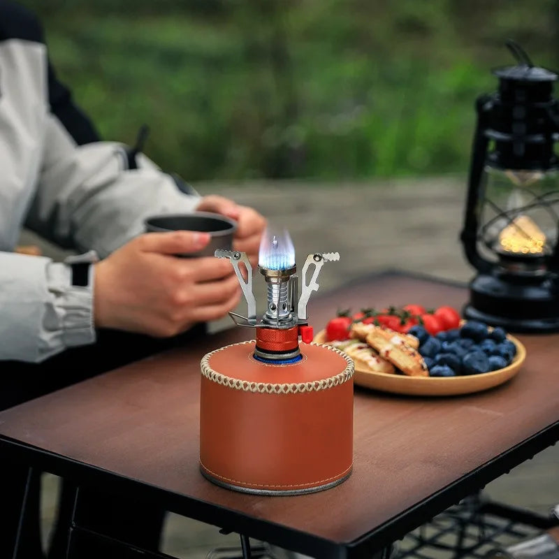 Ultra-light foldable outdoor camping stove with high-efficiency burner for hiking, backpacking, and survival cooking.